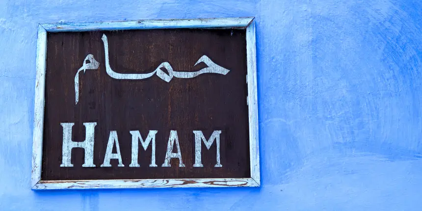 Enseigne « Hamam » en arabe et en français sur un mur bleu